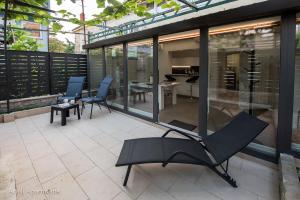 un patio con 2 sillas y una mesa en un edificio en Arieli Apartments Izola en Izola