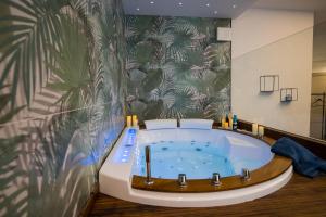 a bathroom with a jacuzzi tub with a palm wallpaper at Maison La Lumia in Palermo