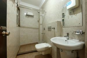 uma casa de banho com um lavatório e um WC em Arkwood Residency B & B At Airport em Nova Deli