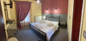 een slaapkamer met een groot bed met witte lakens bij Guesthouse Sinoi in Vytina