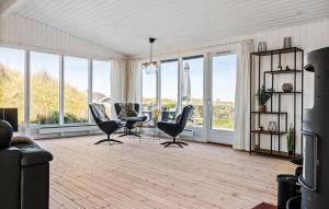 Una sala de estar con sillas y una mesa y ventanas. en 3 Bedroom Stunning Home In Løkken, en Løkken