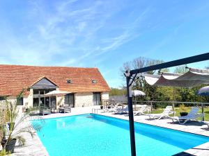 a swimming pool in front of a house at Le domaine du Quercy in Padirac