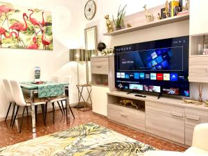 un salon avec une grande télévision et une table dans l'établissement Cristina Boutique Apartment with Terrace, à Viareggio