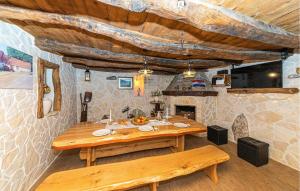 een eetkamer met een houten tafel en banken bij Beautiful Home In Trolokve With Kitchen in Prgomet
