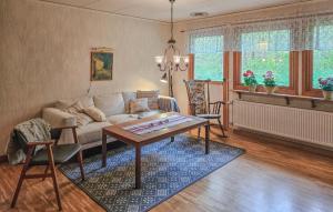 a living room with a couch and a table at Awesome Home In Brånalt With Kitchen in Knäred