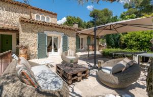 a patio with chairs and an umbrella and a table at Nice Home In Orgon With Private Swimming Pool, Can Be Inside Or Outside in Orgon