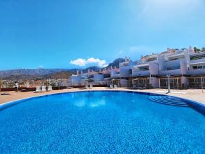 een groot blauw zwembad voor een gebouw bij Royal Sunny Terrace Villas Canarias in Adeje