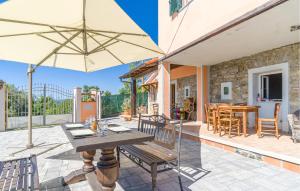 une terrasse avec une table, des chaises et un parasol dans l'établissement Cataverna, à Montedivalli Chiesa