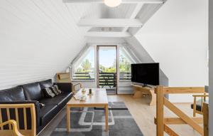 斯波斯比约Beautiful Home In Rudkøbing With Wifi的客厅里有一张黑色沙发和一台电视