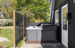 斯波斯比约Beautiful Home In Rudkøbing With Wifi的后院设有烧烤架和围栏