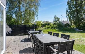 斯波斯比约Beautiful Home In Rudkøbing With Wifi的露台上的木桌和椅子 更多15张照片