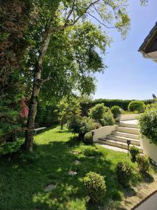 a garden with stairs and green grass and trees at Chambre d'hôte proche d'Étretat in Saint-Jouin-Bruneval