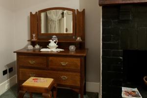 - une commode avec un miroir et un tabouret dans la chambre dans l'établissement Linfield Cottage, à Williamstown