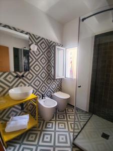 bagno con 2 lavandini, servizi igienici e doccia di Case Borgo Vacanze a Letoianni