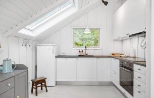ジルレジェにあるBeautiful Home In Gilleleje With Wifiの白いキャビネットと窓付きの白いキッチン +7枚の写真