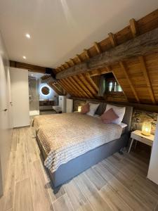 a bedroom with a large bed with a wooden ceiling at Au vieux nid, circuit de spa Francorchamps in Stavelot