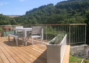 una terrazza in legno con tavolo e sedie. di Millendreath Beach Resort a Looe