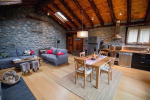 cocina y sala de estar con mesa y sofá en R de rural - Borda del Mollà, en Encamp