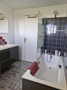 a bathroom with a bath tub and a sink at Chambre d'hôte proche d'Étretat in Saint-Jouin-Bruneval