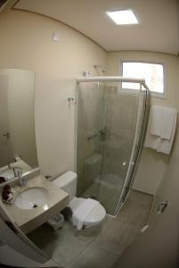 a bathroom with a shower and a toilet and a sink at Wanna Hotel in Lins