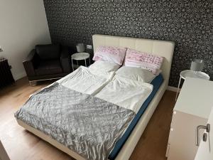 - une chambre avec un lit et une chaise dans l'établissement Wohnung in herzogenrath-strass für max 4 Gäste, à Herzogenrath