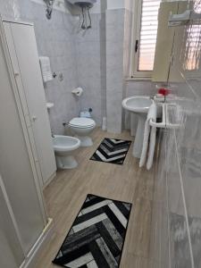 a bathroom with a toilet and a sink and a mirror at Casa Mia in Scilla