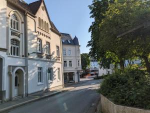 een lege straat in een stad met witte gebouwen bij Schillers Hotel & Café - GARNI - in Lüdenscheid