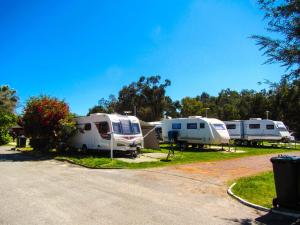 un grupo de tres camionetas estacionadas en un estacionamiento en Acclaim Swan Valley Tourist Park, en West Swan