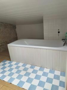 a white bath tub in a bathroom with a sink at Chambres 2 personnes dans notre maison Girondine in Saint-Martin-de-Lerm