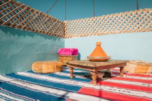 una habitación con una mesa y un perro sobre una alfombra en Moroccan Family House, en Agadir