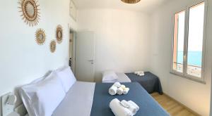 1 Schlafzimmer mit 2 Betten und Handtüchern auf dem Tisch in der Unterkunft Affacciati al mare in Finale Ligure