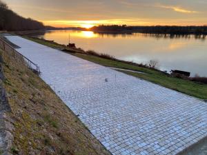 a walkway next to a body of water at Studio de standing en hypercentre proche Loire et parc in Châteauneuf-sur-Loire +2 photos