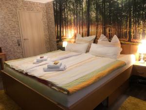 Una cama grande con toallas encima. en Ban Thai Ferienwohnung Bad Steben, en Bad Steben