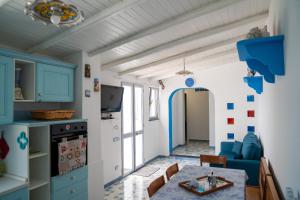 a kitchen and dining room with blue cabinets and a table at Casa Serena in Lipari