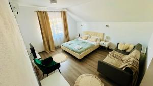 a small bedroom with a bed and a couch at La Jenel in Ciupercenii Noi
