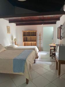 um quarto com uma cama grande e uma mesa em Pousada Robijn em Cabo de Santo Agostinho