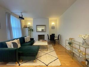 ロンドンにあるQueen bedroom in Maida Valeの緑のソファとテーブルのあるリビングルーム +5枚の写真