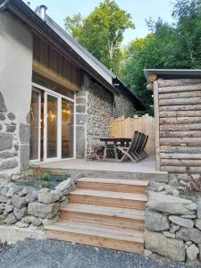a house with a wooden staircase leading to a patio at La Grange de la Gratade in Rochefort-Montagne