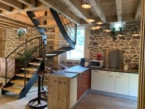 a kitchen with a spiral staircase in a house at La Grange de la Gratade in Rochefort-Montagne +35 photos