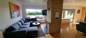a living room with a blue couch and a table at The Dream Villa in Rødby