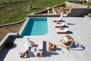 an overhead view of a swimming pool with lounge chairs and a swimming pool at Ventus Villas in Mikonos