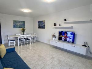 ein Wohnzimmer mit einem TV und einem Esszimmer in der Unterkunft Pasquale's House in Sant'Agnello