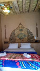 a bedroom with a bed with a mural on the wall at Desert Waves Excursion in Mhamid