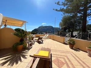 un patio con mesa y sillas en la azotea en Villa Sea view con terrazza e giardino, en Capri