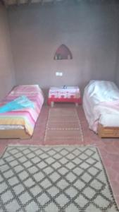 two beds in a room with mats on the floor at Desert Waves Excursion in Mhamid
