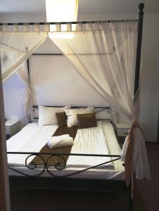 a bedroom with a canopy bed with white sheets and pillows at RHC Royal Hotel in Oradea