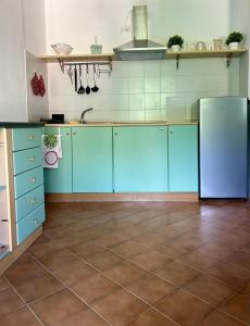 a kitchen with blue cabinets and a refrigerator at Bellagio Neighbor Apartment in Limonta +22 photos