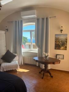un soggiorno con tavolo e finestra di Private Villa Sea VIEW CON TERRAZZA E GIARDINO a Capri