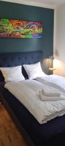 a bedroom with a large bed with a painting on the wall at The Dream Villa in Rødby