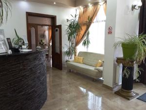 een woonkamer met een bank en een stoel bij RHC Royal Hotel in Oradea